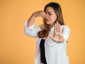 Woman holding nose because of the rotten egg smells coming from her drain