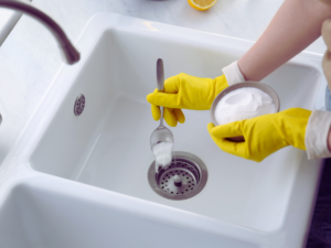 homeowner performing DIY drain cleaning to get rid of drain flies