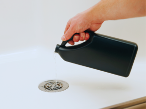 homeowner using drain cleaner for clogged drain
