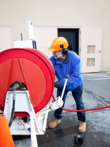Plumber hydro jetting sewer line for clogs on residential property
