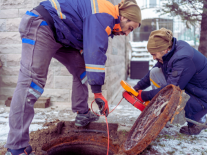 Two plumbers inspecting sewer system 